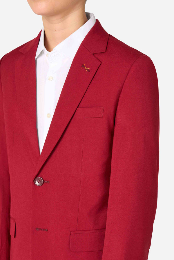 Teenager in einem eleganten burgunderroten Anzug mit weißem Hemd und selbstbewusstem Auftreten. Perfektes formelles Outfit für besondere Anlässe, Hochzeiten und Partys. Brust-Nahaufnahme.