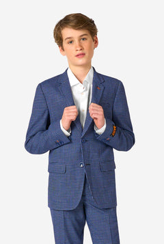 Ein Teenager, der einen dunkelblau-blau karierten Anzug mit einem weißen Hemd trägt. Der Anzug hat eine moderne Passform mit zwei Knöpfen und Pattentaschen. Er steht vor einem schlichten weißen Hintergrund.