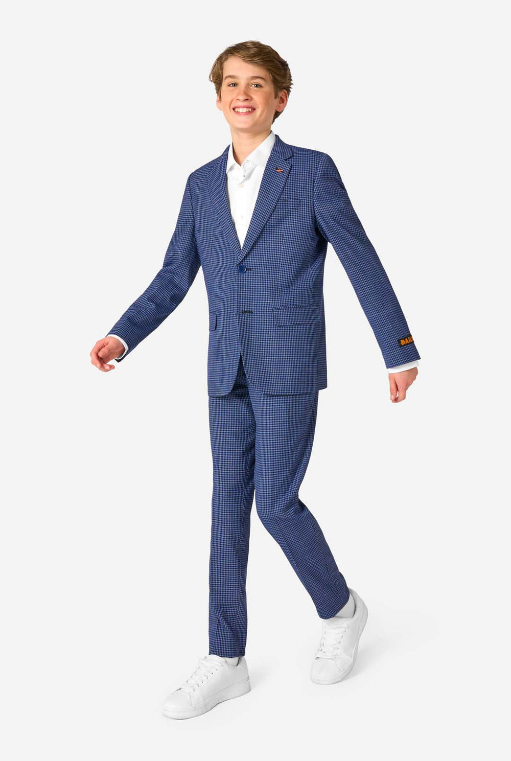 Ein Teenager, der einen dunkelblau-blau karierten Anzug mit einem weißen Hemd trägt. Der Anzug hat eine moderne Passform mit zwei Knöpfen und Pattentaschen. Er steht vor einem schlichten weißen Hintergrund.