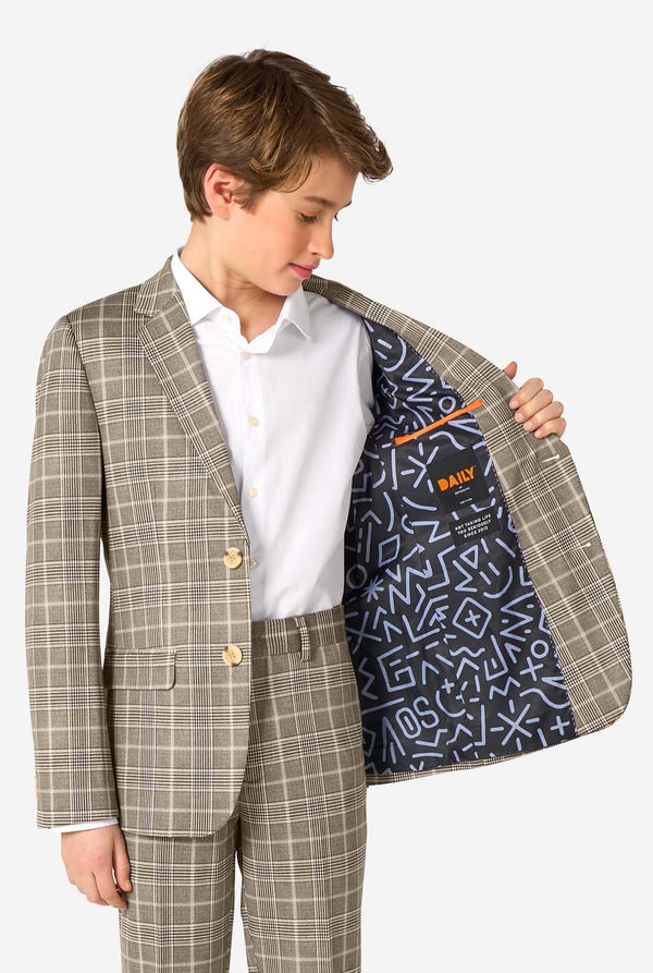 Ein Teenager, der einen hellbraunen karierten Anzug mit einem weißen Hemd trägt. Der Anzug hat eine moderne Passform mit zwei Knöpfen und Pattentaschen. Er steht vor einem schlichten weißen Hintergrund. Hält seine Jacke offen