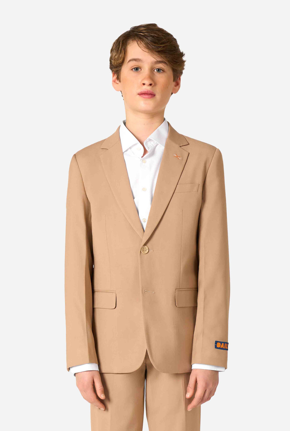 Teenager in einem stylischen hellbraunen/beigen Anzug mit weißem Hemd blickt selbstbewusst in die Kamera. Perfektes formelles Outfit für besondere Anlässe, Hochzeiten und Partys.