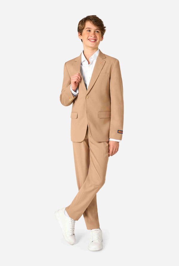 Teenager in einem stylischen hellbraun-beigen Anzug mit weißem Hemd blickt selbstbewusst in die Kamera. Perfektes formelles Outfit für besondere Anlässe, Hochzeiten und Partys. Ganzkörperfoto.