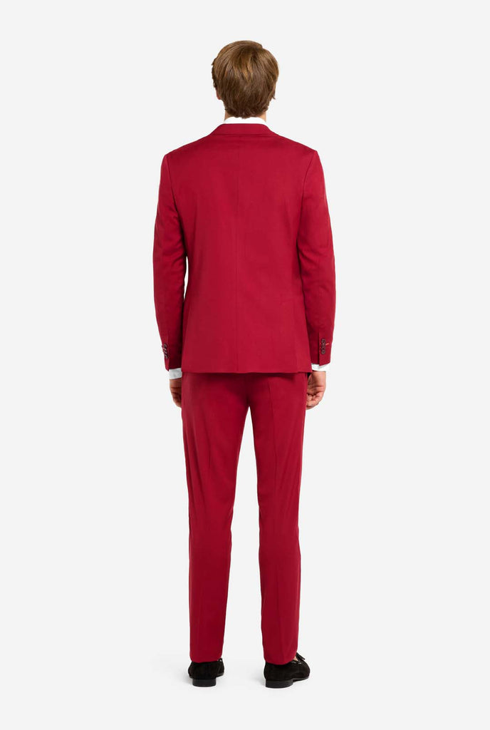 Bild mit hellgrauem Hintergrund und Mann trägt Bright Burgundy Herrenanzug und weißes Hemd. Der Anzug besteht aus Blazer und Hose. Ansicht von hinten.