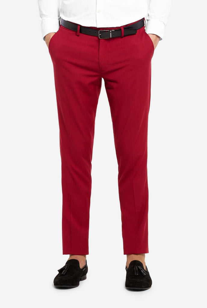 Bild mit hellgrauem Hintergrund und Mann trägt Bright Burgundy Herrenanzug und weißes Hemd. Anzüge besteht aus Blazer und Hose. Konzentriert sich auf die Hose.