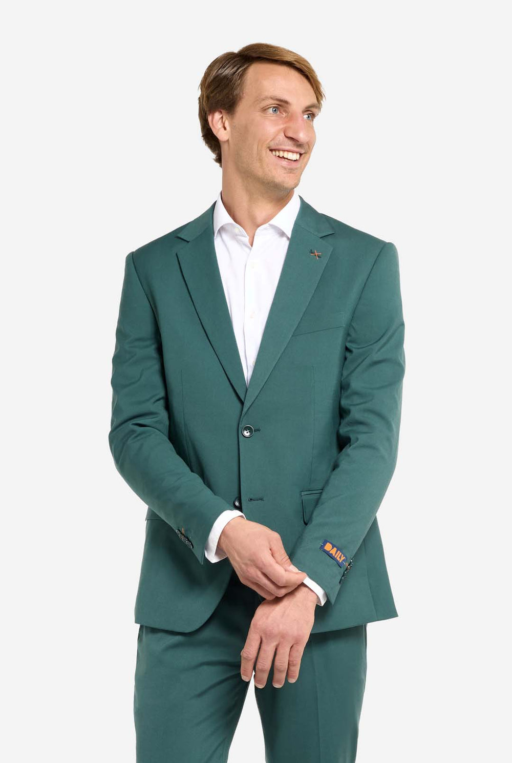 Bild mit hellgrauem Hintergrund und einem Mann in dunkelgrünem Anzug und weißem Hemd. Der Anzug besteht aus Blazer und Hose. Der Mann blickt zur Seite.