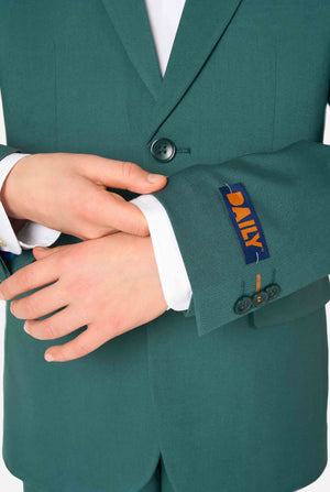 Teenager in einem eleganten dunkelgrünen Anzug mit weißem Hemd und selbstbewusstem Lächeln. Perfektes formelles Outfit für besondere Anlässe, Hochzeiten und Partys. Ärmelnahaufnahme.