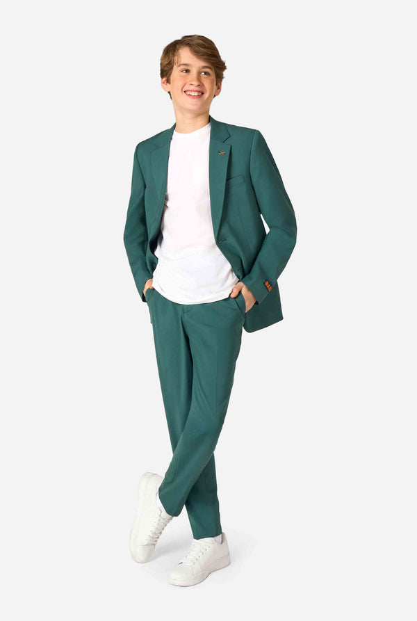 Teenager in einem eleganten dunkelgrünen Anzug mit weißem Hemd und selbstbewusstem Lächeln. Perfektes formelles Outfit für besondere Anlässe, Hochzeiten und Partys. Ganzkörperfoto.