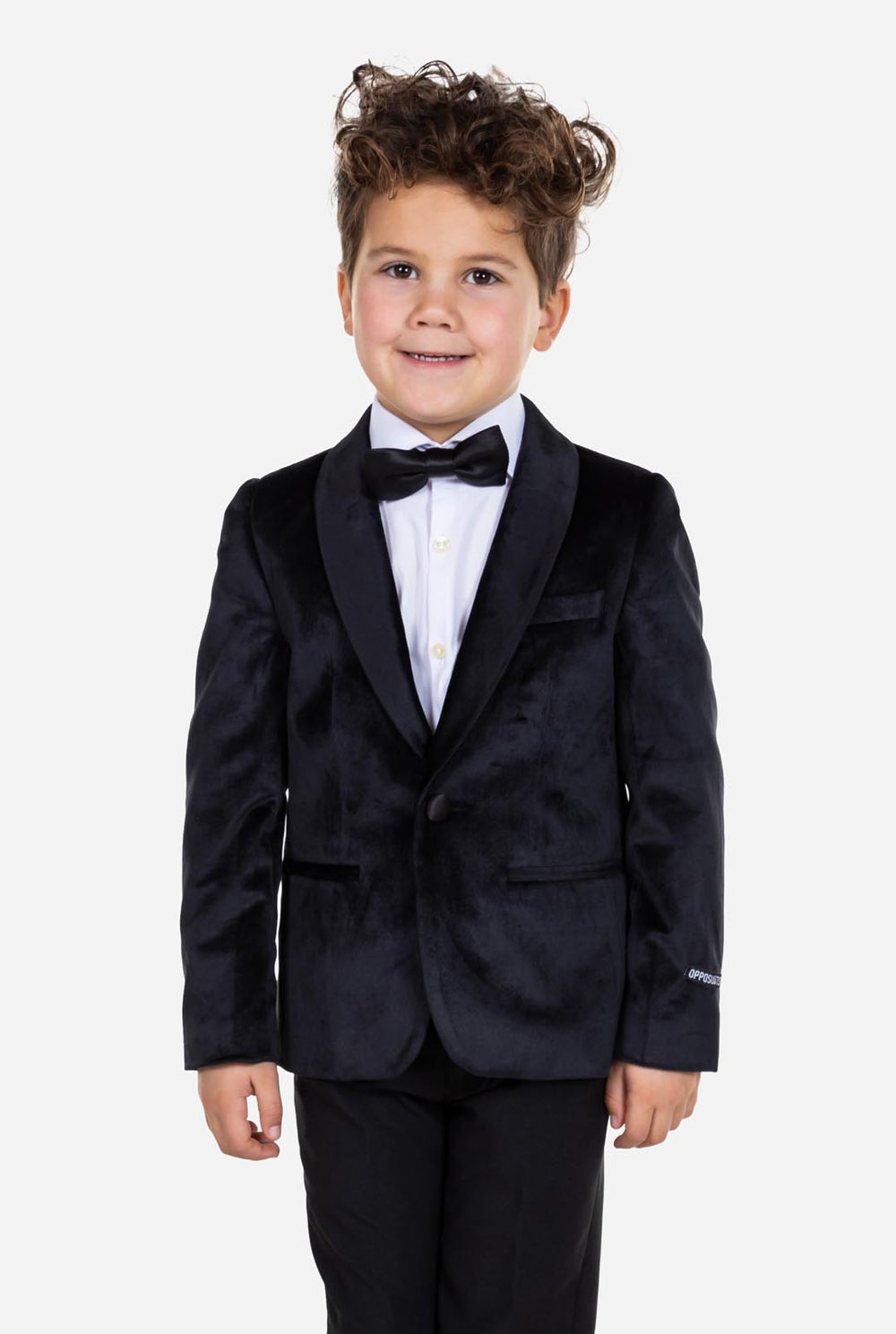 Kind trägt eine schwarze Samt-Smokingsjacke für Jungen.