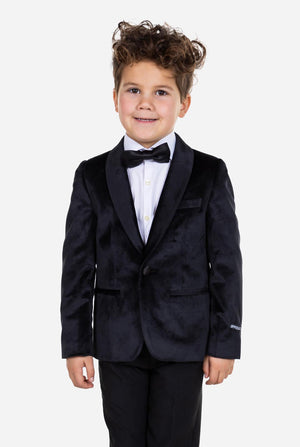 Kind trägt eine schwarze Samt-Smokingsjacke für Jungen.