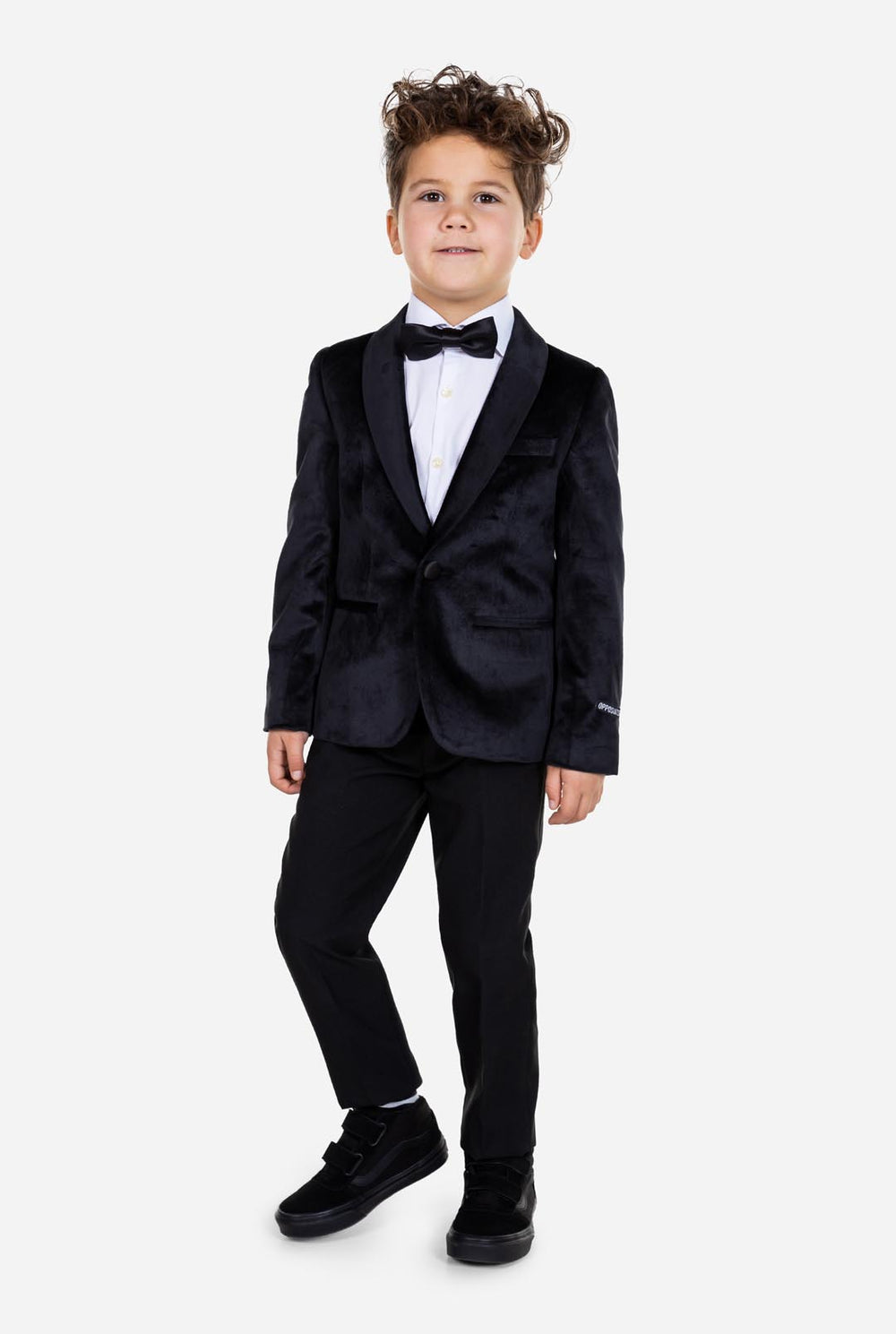 Kind trägt eine schwarze Samt-Smokingsjacke für Jungen.