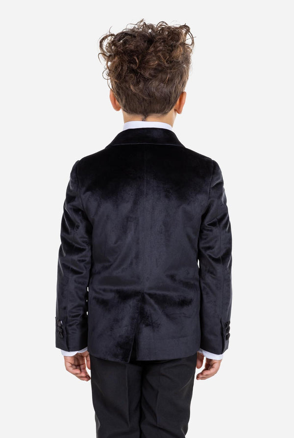 Kind trägt eine schwarze Samt-Smokingsjacke für Jungen.