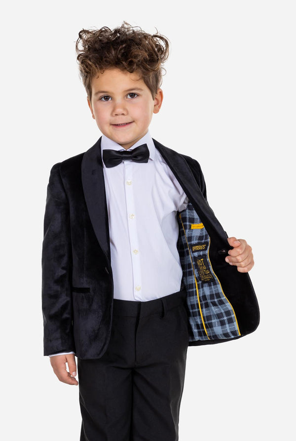 Kind trägt eine schwarze Samt-Smokingsjacke für Jungen.