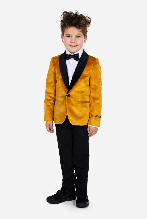 Kind trägt eine goldene Samt-Smokingsjacke für Jungen.
