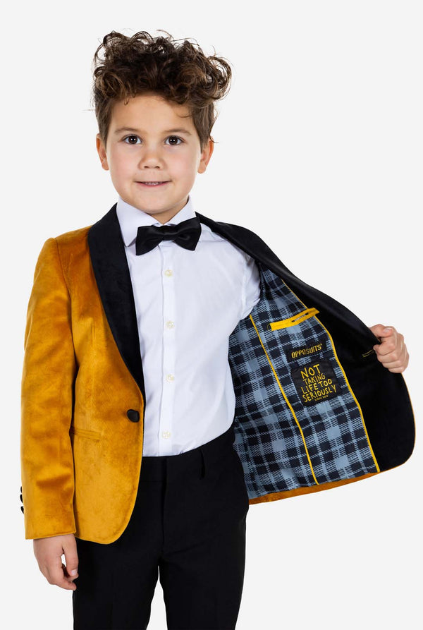 Kind trägt eine goldene Samt-Smokingsjacke für Jungen.