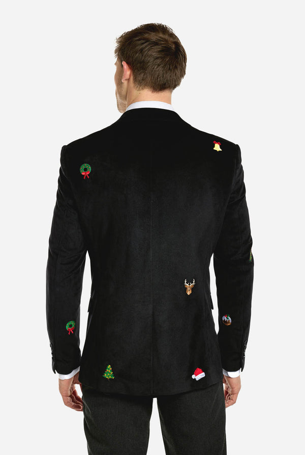 Mann trägt einen schwarzen Weihnachtsblazer mit Weihnachtsikonen