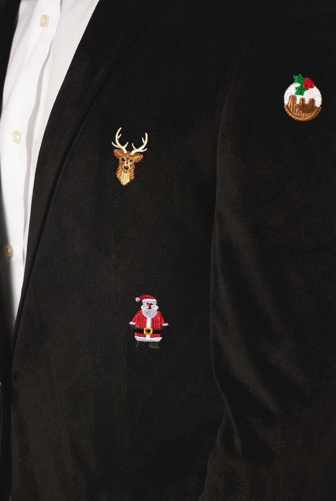 Mann trägt einen schwarzen Weihnachtsblazer mit Weihnachtsikonen