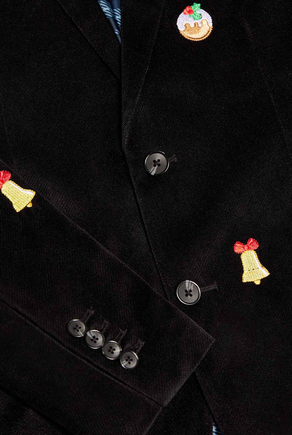 Mann trägt einen schwarzen Weihnachtsblazer mit Weihnachtsikonen