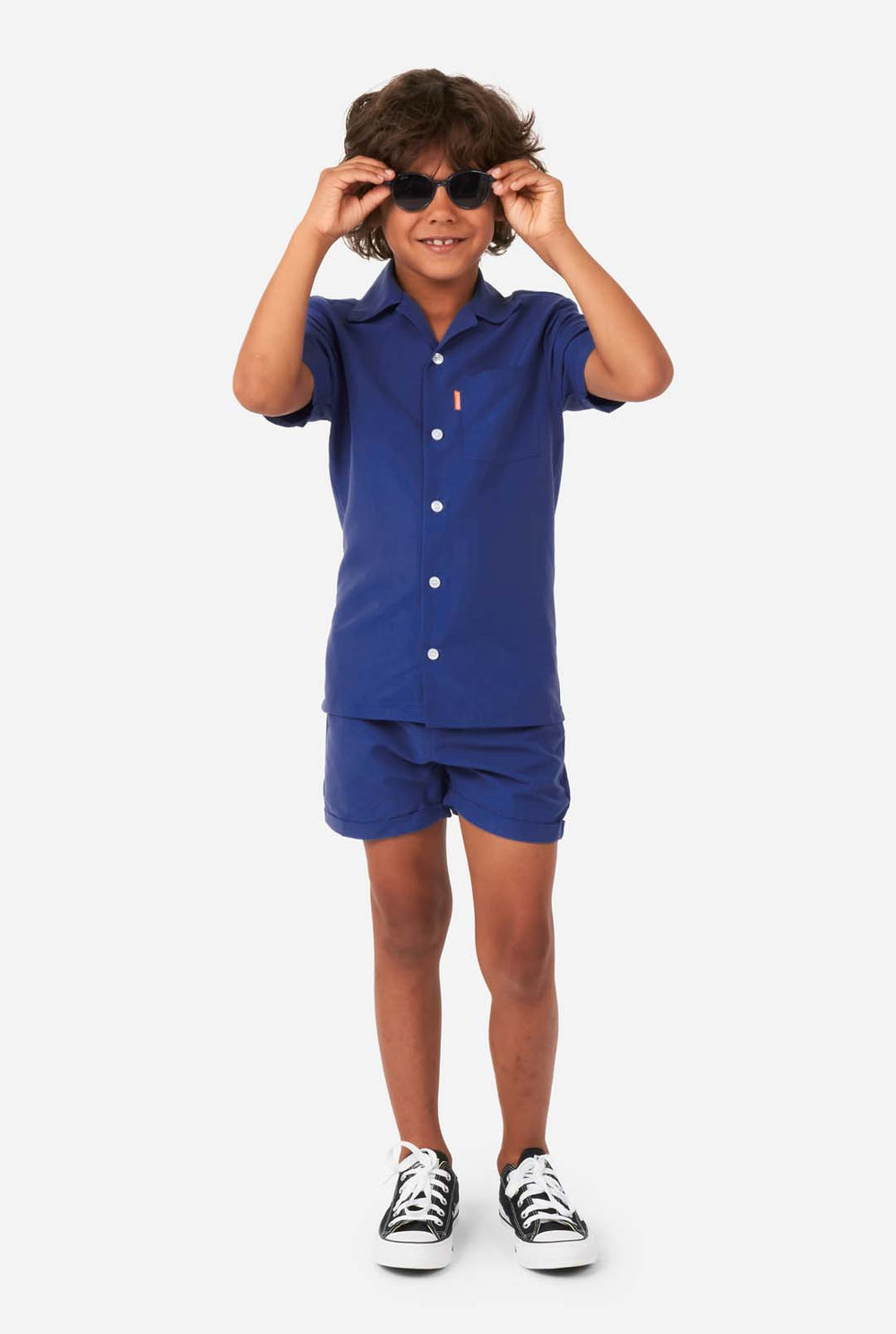 Junge trägt dunkelblaues Sommerset, bestehend aus Shorts und Hemd