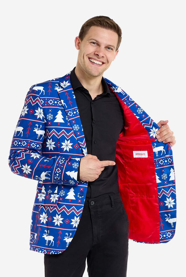 Mann trägt einen blauen Weihnachtsblazer für Herren mit nordischen Weihnachtsfiguren. Er trägt außerdem eine schwarze Hose und ein schwarzes Herrenhemd. Die rote Innenseite der Jacke ist zu sehen.