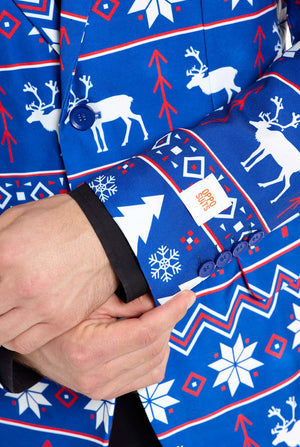 Mann trägt einen blauen Weihnachtsblazer für Herren mit nordischen Weihnachtsfiguren. Er trägt außerdem eine schwarze Hose und ein schwarzes Herrenhemd. Nahaufnahme der Ärmel.