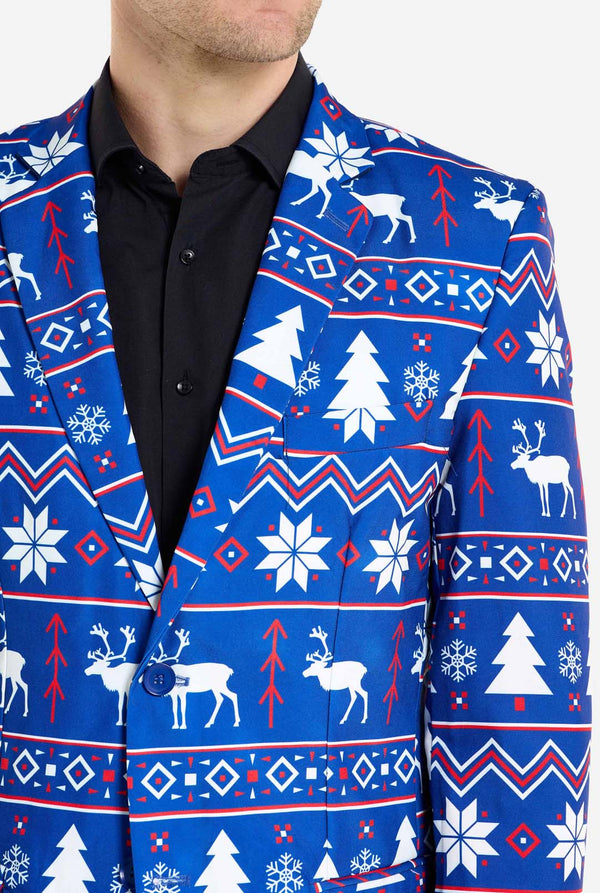 Mann trägt einen blauen Weihnachtsblazer für Männer mit nordischen Weihnachtsfiguren. Er trägt außerdem eine schwarze Hose und ein schwarzes Herrenhemd. Nahaufnahme der Brust.