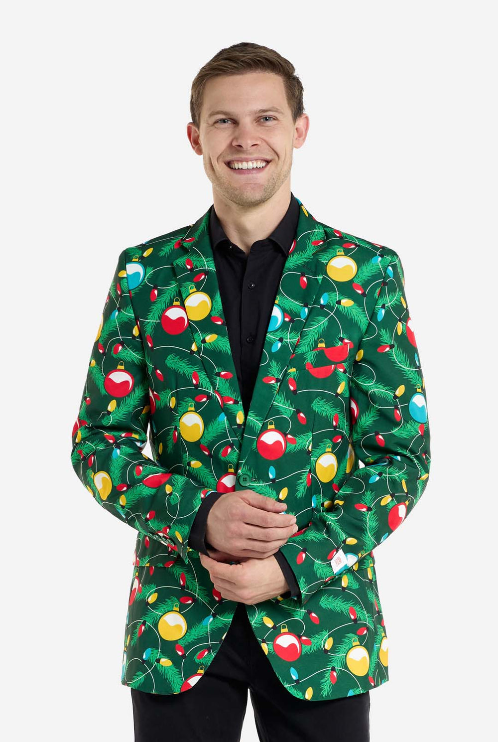 Mann trägt einen grünen Weihnachtsblazer für Herren mit verziertem Weihnachtsbaumaufdruck. Der Mann trägt außerdem eine schwarze Hose und ein schwarzes Herrenhemd.