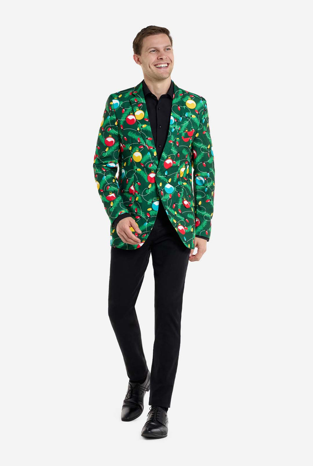 Mann trägt einen grünen Weihnachtsblazer für Herren mit verziertem Weihnachtsbaumaufdruck. Der Mann trägt außerdem eine schwarze Hose und ein schwarzes Herrenhemd.
