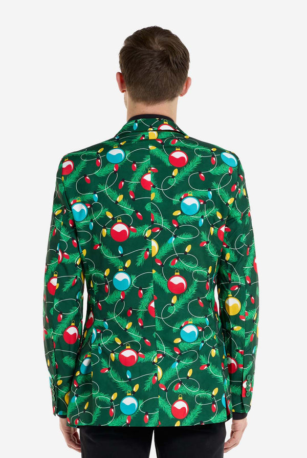 Mann trägt einen grünen Weihnachtsblazer für Herren mit verziertem Weihnachtsbaum-Aufdruck. Der Mann trägt außerdem eine schwarze Hose und ein schwarzes Herrenhemd. Ansicht von hinten.