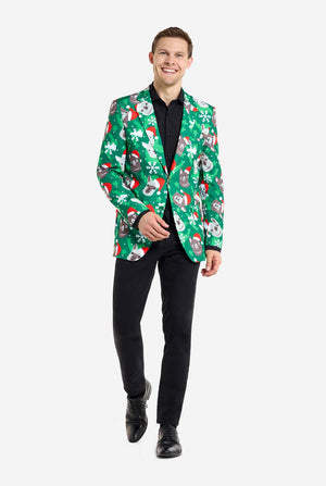 Mann trägt einen grünen Weihnachtsblazer für Männer mit Weihnachtslamas. Der Mann trägt außerdem eine schwarze Hose und ein schwarzes Herrenhemd. Ganzkörperbild.