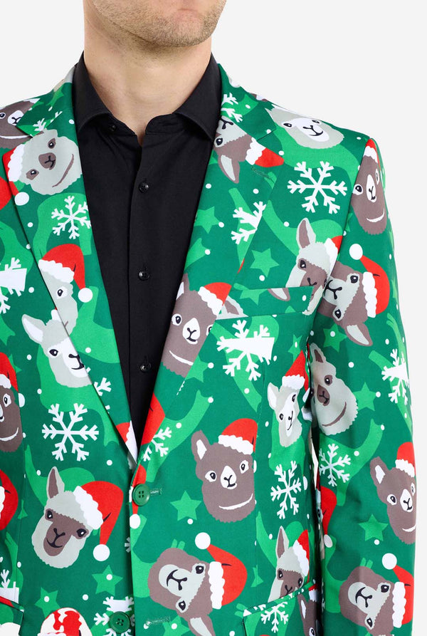 Mann trägt grünen Weihnachtsblazer für Männer mit Weihnachtslamas. Außerdem trägt er eine schwarze Hose und ein schwarzes Herrenhemd. Nahaufnahme der Brust.