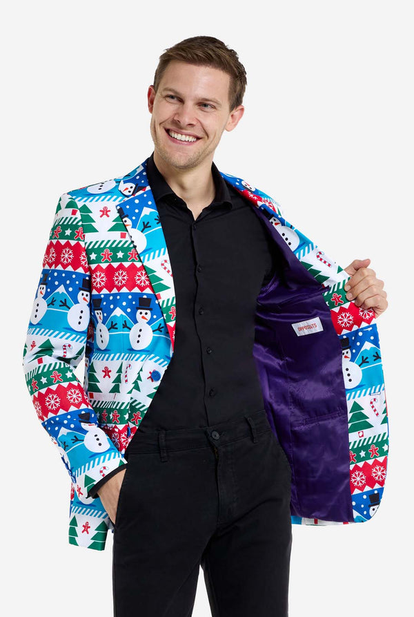 Mann trägt einen Weihnachtsblazer für Männer mit weihnachtlichen Winterfiguren. Er trägt außerdem eine schwarze Hose und ein schwarzes Herrenhemd. Die Innenseite der Jacke ist lila.