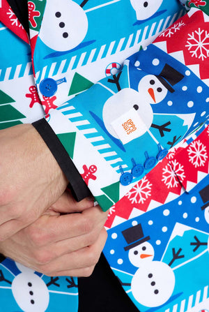 Mann trägt einen Weihnachtsblazer für Männer mit weihnachtlichen Winterfiguren. Er trägt außerdem eine schwarze Hose und ein schwarzes Herrenhemd. Nahaufnahme der Ärmel.