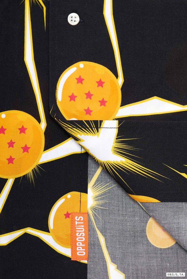 Mann trägt ein schwarzes Hawaiihemd mit Dragon Ball Z-Aufdruck, auf dem Dragon Balls und Lichter zu sehen sind. 