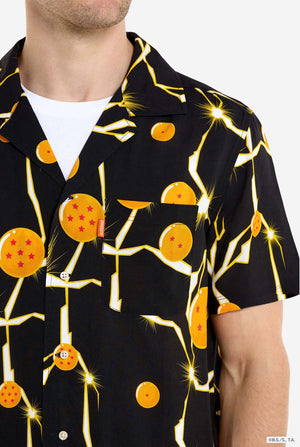 Mann trägt ein schwarzes Hawaiihemd mit Dragon Ball Z-Aufdruck, auf dem Dragon Balls und Lichter zu sehen sind. 