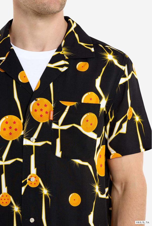 Mann trägt ein schwarzes Hawaiihemd mit Dragon Ball Z-Aufdruck, auf dem Dragon Balls und Lichter zu sehen sind. 