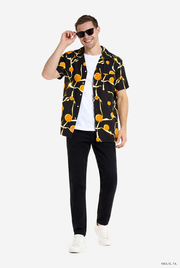 Mann trägt ein schwarzes Hawaiihemd mit Dragon Ball Z-Aufdruck, auf dem Dragon Balls und Lichter zu sehen sind. 