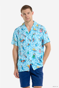 Image of a man wearing a Hawaiian shirt with a One Piece print. Hawaiian shirt is manly blue and white representing the sea and has the Straw Hat Pirates crew on it and it looks like the are floating in the sea. Man is also wearing blue shorts.