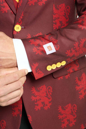 Bild mit hellgrauem Hintergrund und einem Mann, der einen Harry-Potter-Anzug im Gryffindor-Stil trägt. Der Anzug besteht aus einem roten Blazer mit Gryffindor-Logo und einem hellroten Löwen-Allover-Print, schwarzen Hosen und einer rot-gelb diagonal gestreiften Krawatte. Nahaufnahme des Ärmels.