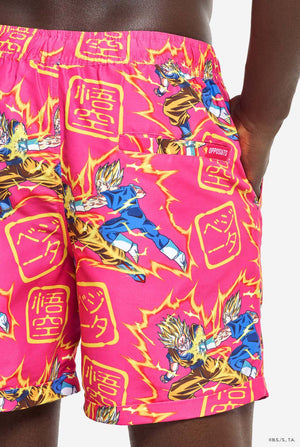 Mann trägt ein rosa Sommerset bestehend aus Hemd und Shorts. Das Sommerset ist mit einem Dragon Ball Z-Aufdruck von Goku und Vegeta versehen.