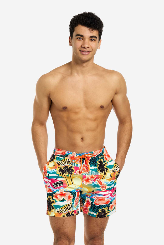 Man wearing swim trunks with tropical Hawaiian print