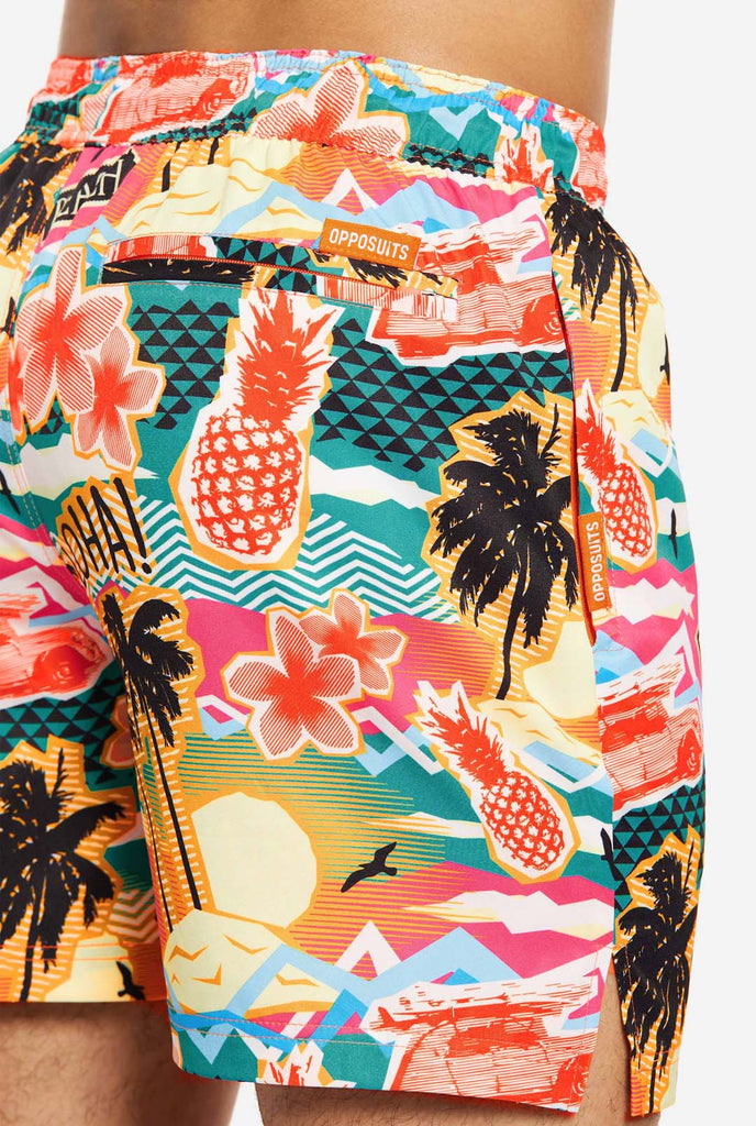 Man wearing swim trunks with tropical Hawaiian print, close up