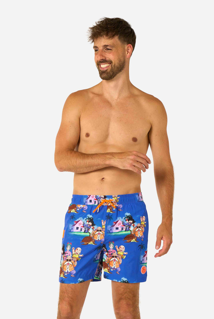 Blaue Badeshorts für Herren mit Dragon Ball-Motiv mit Goku, Krillin, Master Roshi und anderen Charakteren von Kame House. Perfekt für Anime-Fans am Strand oder Pool.