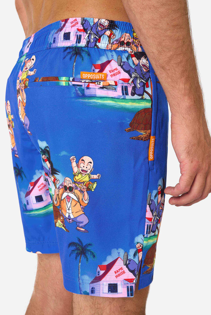 Blaue Badeshorts für Herren mit Dragon Ball-Motiv mit Goku, Krillin, Master Roshi und anderen Charakteren von Kame House. Perfekt für Anime-Fans am Strand oder Pool.