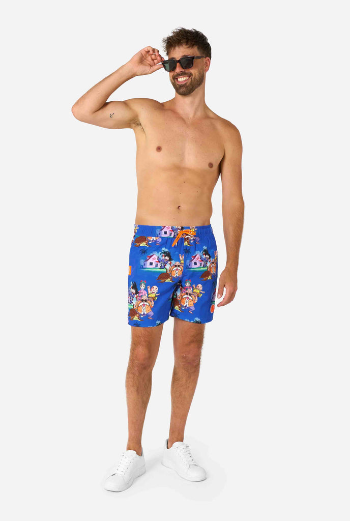 Blaue Badeshorts für Herren mit Dragon Ball-Motiv mit Goku, Krillin, Master Roshi und anderen Charakteren von Kame House. Perfekt für Anime-Fans am Strand oder Pool.