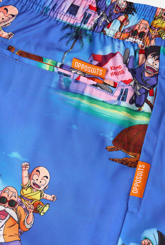 Blaue Badeshorts für Herren mit Dragon Ball-Motiv mit Goku, Krillin, Master Roshi und anderen Charakteren von Kame House. Perfekt für Anime-Fans am Strand oder Pool.