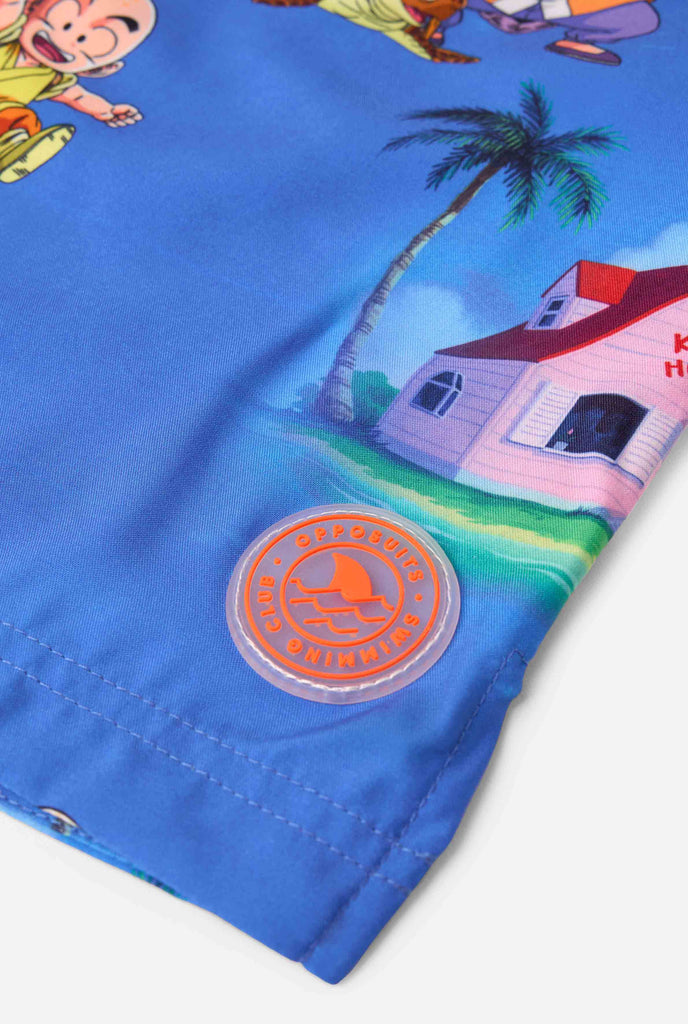 Blaue Badeshorts für Herren mit Dragon Ball-Motiv mit Goku, Krillin, Master Roshi und anderen Charakteren von Kame House. Perfekt für Anime-Fans am Strand oder Pool.