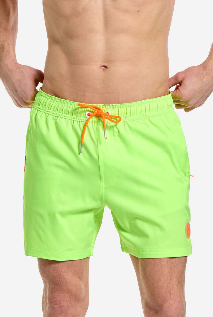 Man wearing Neon lime green swim trunks for men, close up