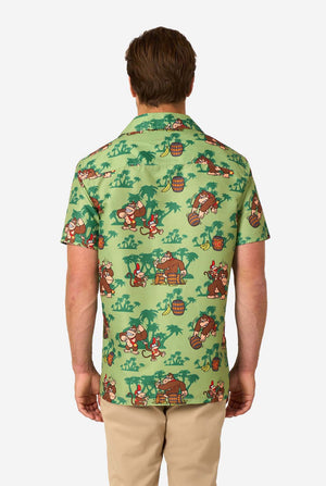Bild eines Mannes, der ein Hawaiihemd mit Donkey-Kong-Motiv trägt. Das T-Shirt hat einen hellgrünen Hintergrund und enthält dunkelgrüne Palmen sowie mehrere Bilder der Figur Donkey Kong aus Super Mario. Ansicht von hinten.