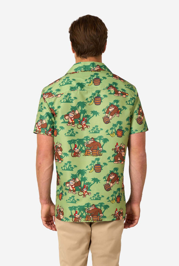 Bild eines Mannes, der ein Hawaiihemd mit Donkey-Kong-Motiv trägt. Das T-Shirt hat einen hellgrünen Hintergrund und enthält dunkelgrüne Palmen sowie mehrere Bilder der Figur Donkey Kong aus Super Mario. Ansicht von hinten.