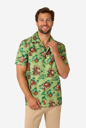 Bild eines Mannes, der ein Hawaiihemd mit Donkey-Kong-Motiv trägt. Das T-Shirt hat einen hellgrünen Hintergrund und enthält dunkelgrüne Palmen sowie mehrere Bilder der Figur Donkey Kong aus Super Mario. Der Mann blickt in die Kamera.